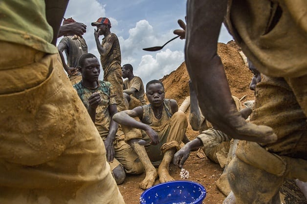 Miners eat lunch from a communal bowl in the mining town of Pluto in Ituri Province. They work here to extract rock and sand from a large pit which has taken over a year to excavate. The miners are made up of many different people from all over Congo who come to seek their fortune. Fixer Pastor Marrion Pudongo +243999836650 marrionudongo@yahoo.fr
